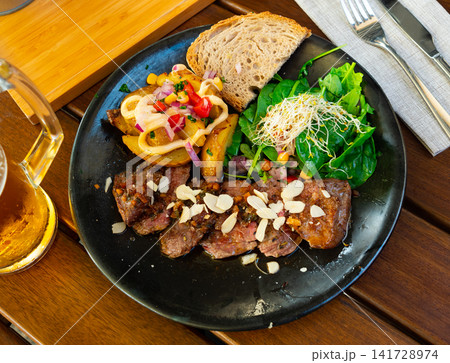 Portion of roasted veal with vegetables 141728974
