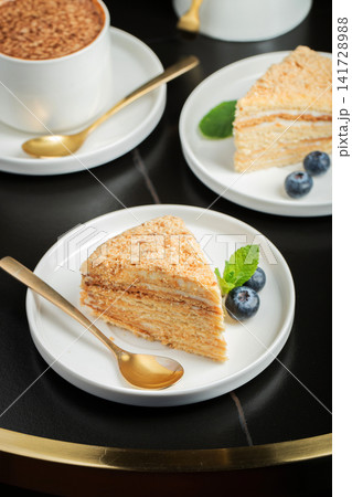 Medovik. Honey cake made from honey cakes with whipped sour cream, decorated with berries, pomegranate and flowers 141728988
