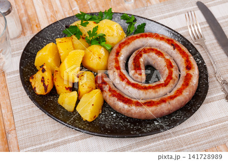 Juicy roasted botifarra with fried potatoes 141728989