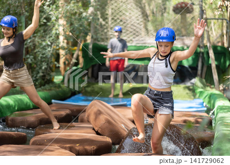 group of people goes through an obstacle course in an amusement park group of people goes through an obstacle course in an amusement park 141729062