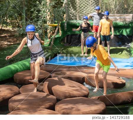 Two teams compete on an obstacle course in amusement park Two teams compete on an obstacle course in amusement park 141729188