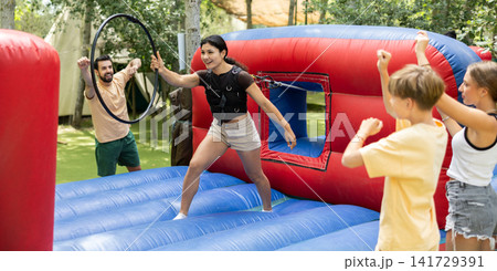 Woman stands on an inflatable attraction and tries to put on a ring 141729391