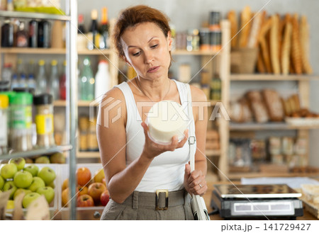 Adult woman choosing cheese in grocery store 141729427