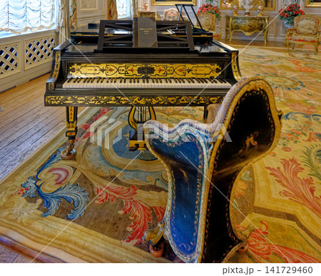 Antique Erard grand piano with inlaid wood decorations and ornate chair at Waddesdon Manor Antique Erard grand piano with inlaid wood decorations and ornate chair at Waddesdon Manor 141729460