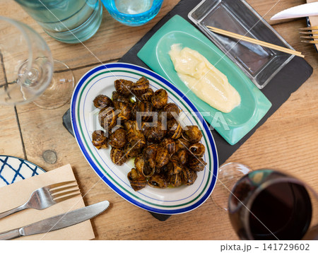 Top view of plate with traditional Spanish tapa Caracoles en salsa - snails stewed to homemade 141729602