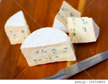 Slices of blue cheese on wooden cutting board 141729603