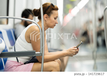 Portrait of pretty woman commuting in city using subway train Portrait of pretty woman commuting in city using subway train 141729617