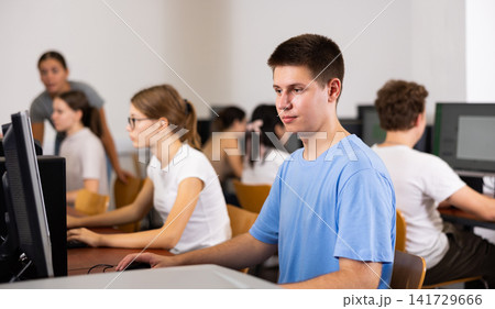 Teenage boy using computer during lesson Teenage boy using computer during lesson 141729666