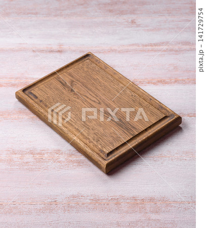 A square wooden cutting board for home food preparation. A wooden cutting board A square wooden cutting board for home food preparation. A wooden cutting board 141729754