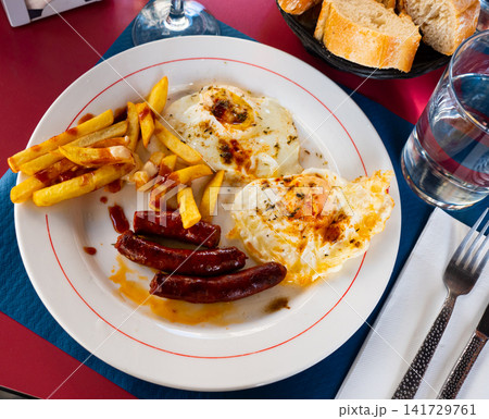 Popular spanish dish is fried eggs with chistorra and potatoes Popular spanish dish is fried eggs with chistorra and potatoes 141729761