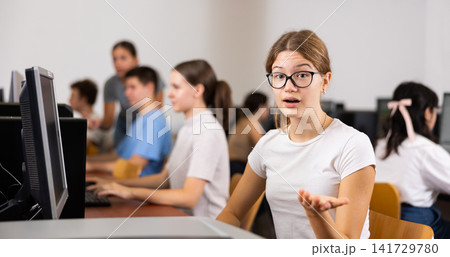 Focused female student in glasses using PC and studying computer science in the classroom Focused female student in glasses using PC and studying computer science in the classroom 141729780