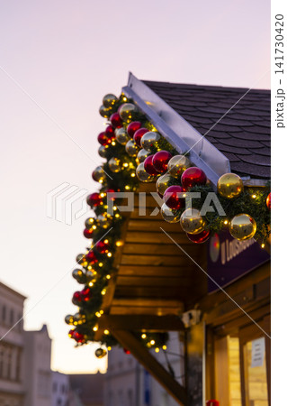 Christmas market stall decorating with festive ornaments and lights Christmas market stall decorating with festive ornaments and lights 141730420