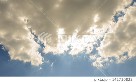 clearing of blue sky below volumetric light clouds penetrated by bright sunlight 141730822