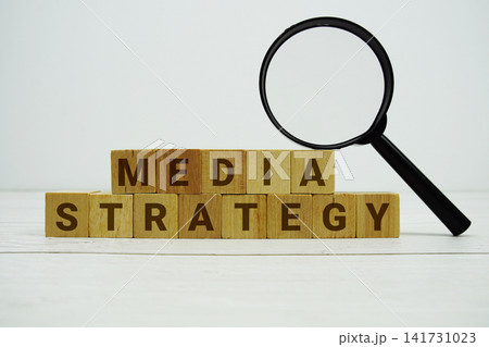 MEDIA STRATEGY alphabet letters with magnifying glass on wooden background MEDIA STRATEGY alphabet letters with magnifying glass on wooden background 141731023