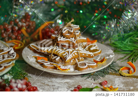 Playful gingerbread designs in multiple shapes are arranged on textured rustic background. Detailed icing adds decorative festive elements. Playful gingerbread designs in multiple shapes are arranged on textured rustic background. Detailed icing adds decorative festive elements. 141731180