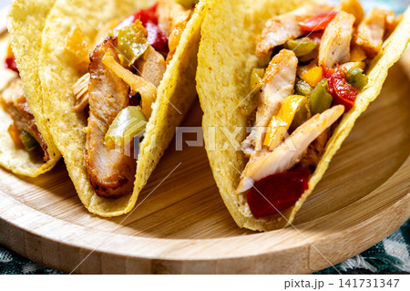 Mexican chicken tacos with bell peppers and onions 141731347