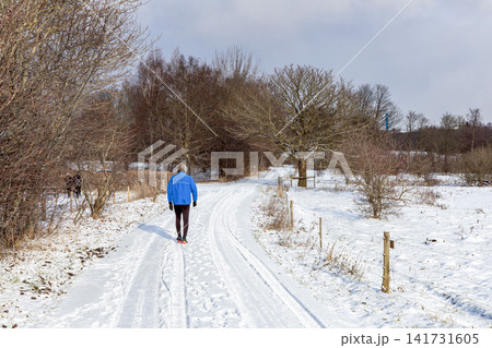 Winter outdoor run with healthy male walking in park. 141731605