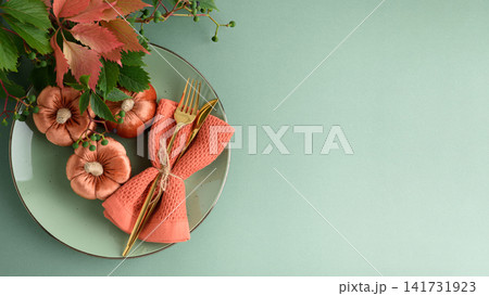Autumn Table Setting With Velvet Pumpkins Napkin Cutlery And Greenery Autumn Table Setting With Velvet Pumpkins Napkin Cutlery And Greenery 141731923