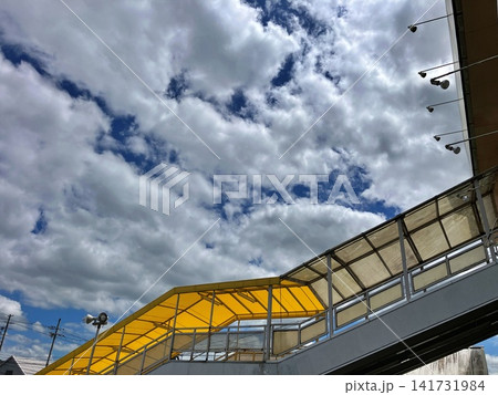 黄色い屋根の歩道橋と夏の入道雲が広がる青空の風景 黄色い屋根の歩道橋と夏の入道雲が広がる青空の風景 141731984