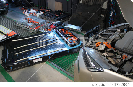 Spare high voltage batteries for electric vehicles are laid out on the garage floor. Battery replacement and maintenance of electric vehicles Spare high voltage batteries for electric vehicles are laid out on the garage floor. Battery replacement and maintenance of electric vehicles 141732004