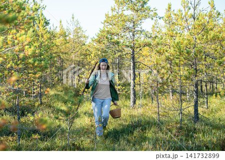 Confident woman backpacker strolling through forest, physical activity outdoors and healthy living Confident woman backpacker strolling through forest, physical activity outdoors and healthy living 141732899