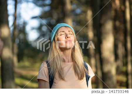 Calm positive woman embracing nature on healing solo trip in woods, peaceful retreat away from city. Calm positive woman embracing nature on healing solo trip in woods, peaceful retreat away from city. 141733146