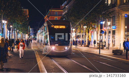 Nice, France - November 2, 2018 - Tram at night on Massena square with pedestrians Nice, France - November 2, 2018 - Tram at night on Massena square with pedestrians 141733160