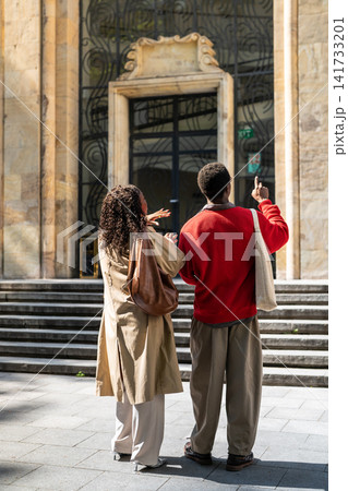 Interested positive african american couple man and woman enjoying walking exploring city together. 141733201