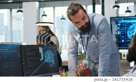 Manager supervising developer with paraplegia writing code, developing deep learning APIs. Supervisor overseeing work done by IT expert in wheelchair troubleshooting software errors using AI, camera A Manager supervising developer with paraplegia writing code, developing deep learning APIs. Supervisor overseeing work done by IT expert in wheelchair troubleshooting software errors using AI, camera A 141733416