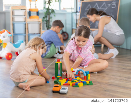 Kids playing with colorful educational toys on blurred kindergarten room background Kids playing with colorful educational toys on blurred kindergarten room background 141733766