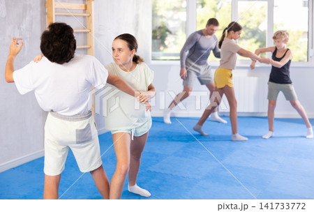 Boy and girl train to perform works out blow to jaw at opponent, while learning self-defense 141733772
