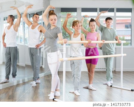 Ballet lesson for teenagers - choreographer teaches girls and boys ballet steps in studio Ballet lesson for teenagers - choreographer teaches girls and boys ballet steps in studio 141733773