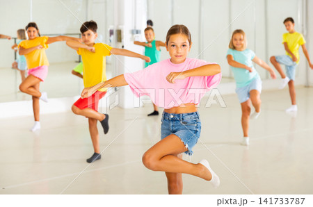 Group of children are learning dance moves in modern studio Group of children are learning dance moves in modern studio 141733787