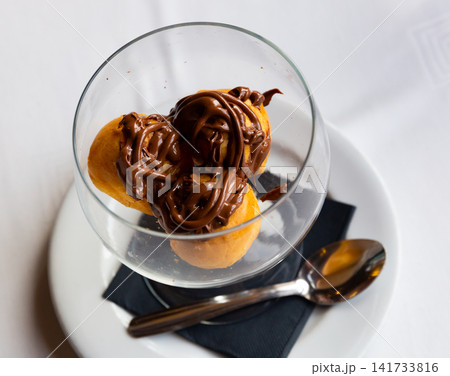 Cream profiteroles with hot chocolate Cream profiteroles with hot chocolate 141733816