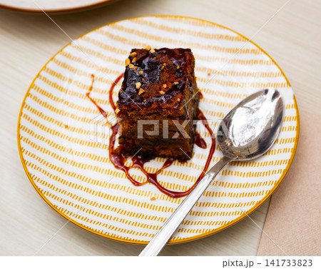Traditional spanish dessert Tarta de zanahoria. Slice of carrot cake with chocolate syrup Traditional spanish dessert Tarta de zanahoria. Slice of carrot cake with chocolate syrup 141733823