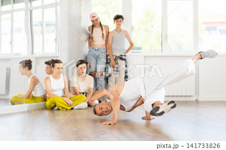 Dance teacher shows how to dance low breaking in studio 141733826