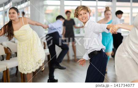 Cheerful boy dancing jive with female partner at choreography class Cheerful boy dancing jive with female partner at choreography class 141734077