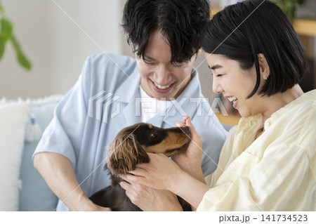 笑顔の30代の男女と愛犬のミニチュアダックス 笑顔の30代の男女と愛犬のミニチュアダックス 141734523