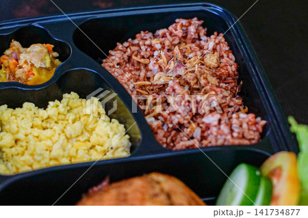 Healthy meal prep box with red rice, scrambled eggs and vegetables. Fitness nutrition and clean eating concept. Healthy meal prep box with red rice, scrambled eggs and vegetables. Fitness nutrition and clean eating concept. 141734877