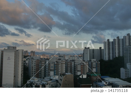 Urban apartment complex under a blue sky and fluffy white clouds 141735118