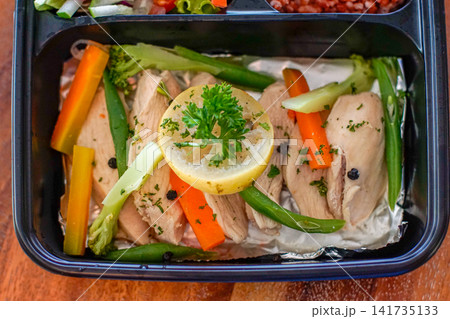 Healthy high protein meal with sliced chicken breast, steamed vegetables and lemon in a food container. Clean eating and nutrition concept for lifestyle and wellness use. 141735133