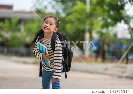 happy student carrying a schoolbag and holding book on the first day of semester. Back to school concept. happy student carrying a schoolbag and holding book on the first day of semester. Back to school concept. 141735514