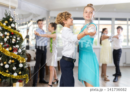 Enthusiastic adolescent dancers practicing partner dance in Christmas studio Enthusiastic adolescent dancers practicing partner dance in Christmas studio 141736082