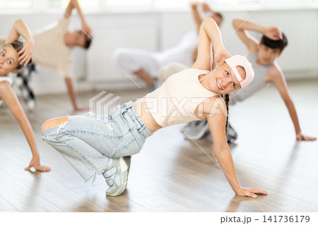 Teenage girl dancing breakdancing in group 141736179