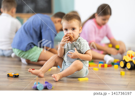6 year boy plays with toys in front of other children in kindergarten 6 year boy plays with toys in front of other children in kindergarten 141736197