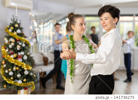 Couples dancing - teenagers in festive clothes dance the Viennese waltz near Christmas tree 141736275