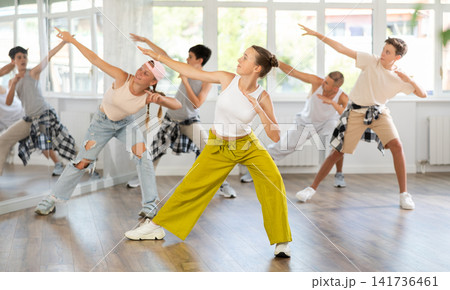 Teen girl with group of teenage friends, learn to dance hip hop Teen girl with group of teenage friends, learn to dance hip hop 141736461