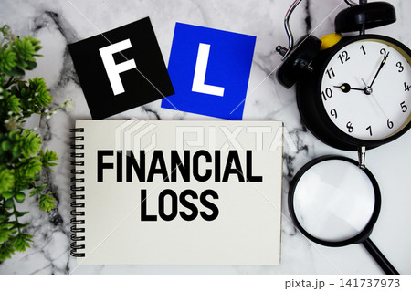 FL Financial Loss text written on notepad with alarm clock and magnifying glass on marble background 141737973