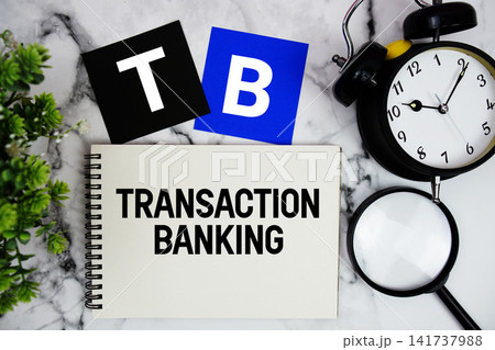 TB Transaction Banking text written on notepad with alarm clock and magnifying glass on marble background TB Transaction Banking text written on notepad with alarm clock and magnifying glass on marble background 141737988
