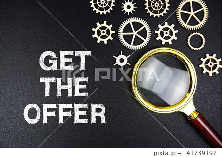 Get The Offer text message with magnifying glass on black background Get The Offer text message with magnifying glass on black background 141739197